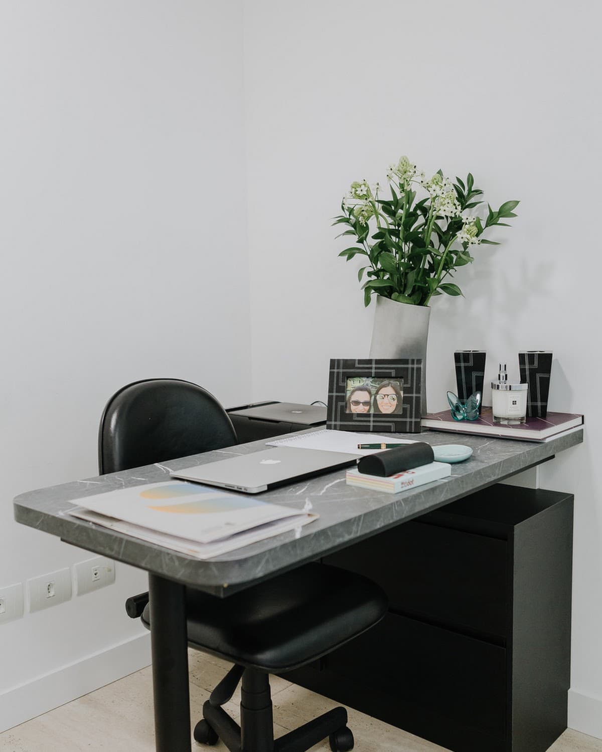 Consultório com mesa e arranjo floral